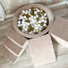 Donkerbeige ballenbad van bovenaf met witte, beige en goudkleurige ballen, een trapje, helling en balk.