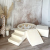 Ecru ballenbad met witte en beige ballen, een trapje, helling en balk naast een pluchen giraf.