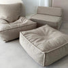 Beige bouclé ottoman kinderpoef op de voorgrond, met een bijpassende zitzak en lounger erachter.