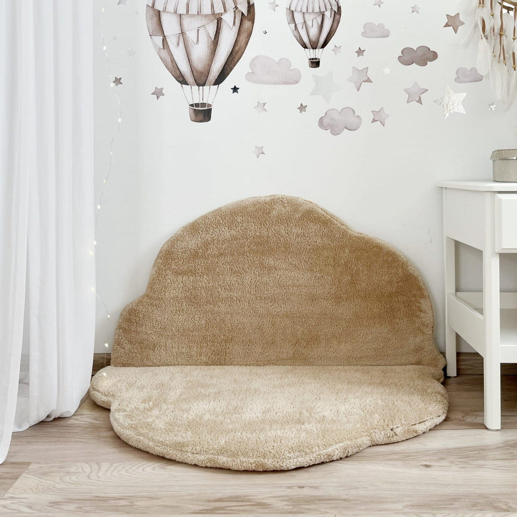 Beige teddy speelmat Cloud met één helft tegen de muur als zitje, onder muurstickers van luchtballonnen.