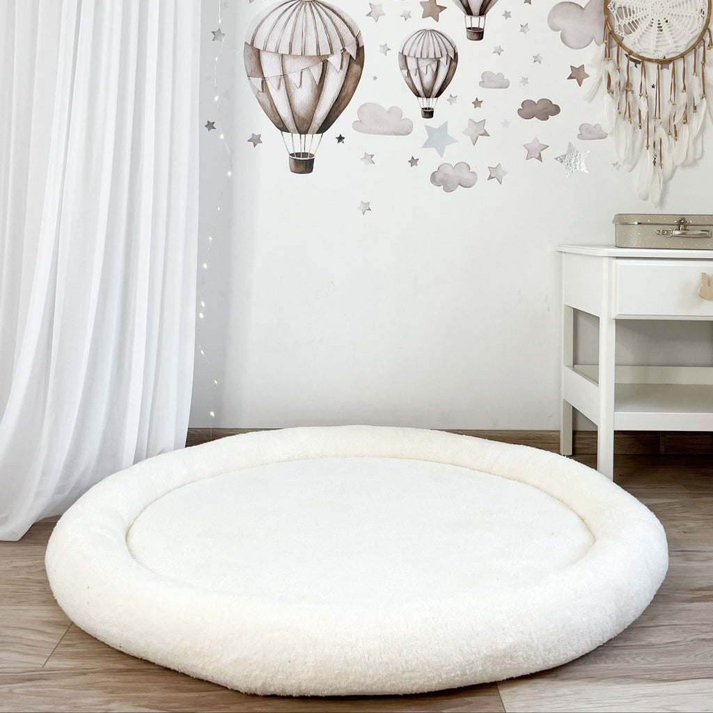 Wit teddy speelnest op een houten vloer in een kinderkamer met luchtballonnen op de muur